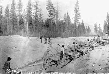 En 1884, des travailleurs chinois s’affairent, dans les montagnes, à la construction du chemin de fer transcanadien. (Canadien Pacifique)