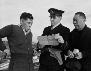 Esquimault, British Columbia; December 9,1941--Internment Camps--R.C.N. officer questioning Japanese Canadian fishermen while confiscating their boat, Esquimault, British Columbia, 9 December 1941(CP PHOTO) 1999 (National Archives of Canada) PA-112539