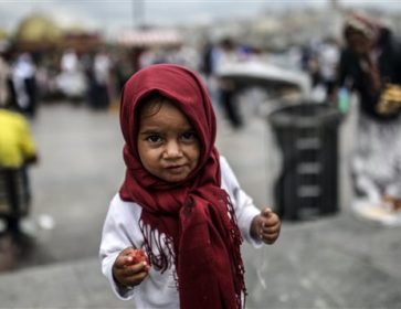 Une jeune réfugiée syrienne mange des restes que sa mère a trouvé dans une poubelle, à Istanbul. © Getty Images/AFP/Bulent Kilic