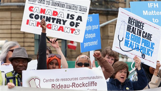 Des manifestants contre la réforme des soins de santé aux réfugiés, devant la colline du Parlement, à Ottawa  Photo :  PC/FRED CHARTRAND