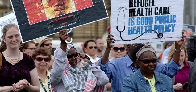 Des manifestants en 2014 devant la colline du Parlement du Canada pour dénoncer la réforme des soins de santé aux réfugiés. Photo : PC/Sean Kilpatrick