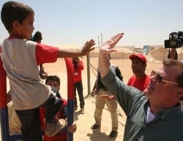 Le ministre canadien des Affaires étrangères John Baird accueille un réfugié syrien garçon s au camp de réfugiés de Zaatari, à Mafraq, Jordanie, samedi. (Mohammad Hannon / Associated Press)