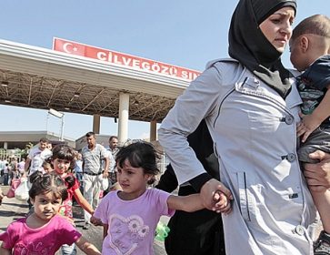Des réfugiés syriens traversent la frontière turque. Gregorio Borgia / Associated Press