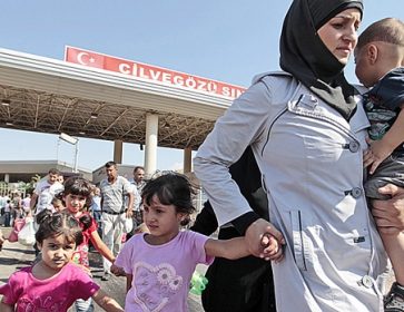 Des réfugiés syriens traversent la frontière turque. Gregorio Borgia / Associated Press