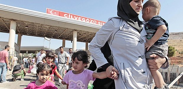 Des réfugiés syriens traversent la frontière turque. Gregorio Borgia / Associated Press