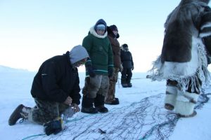 Des chasseurs inuits se préparent à tendre leurs filets dans une fissure entre deux plaques de glace. Photo Levon Sevunts.