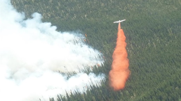Un avion-citerne déverse sa cargaison de liquide ignifuge près d'un brasier au Yukon. (Yukon Wildland Fire management)