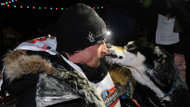 Moment de tendresse entre le vainqueur de la course Iditarod, Dallas Seavey et un des ses chiens au fil d'arrivé. (Bob Hallinen/Anchorage Daily News/La Presse Canadienne)