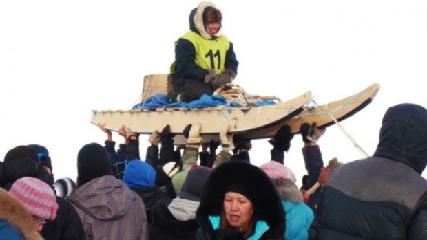 The crowd hoists up one of the mushers in the 2013 Nunavut Quest race from Arctic Bay to Igloolik. (Photo courtesy of Angela Coxon)