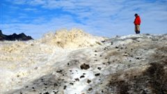 Steve Grasby se trouve à côté d’une source de soufre jaillissant du glacier à Borup Fiord Pass. (Benoit Beauchamp / Université de Calgary)