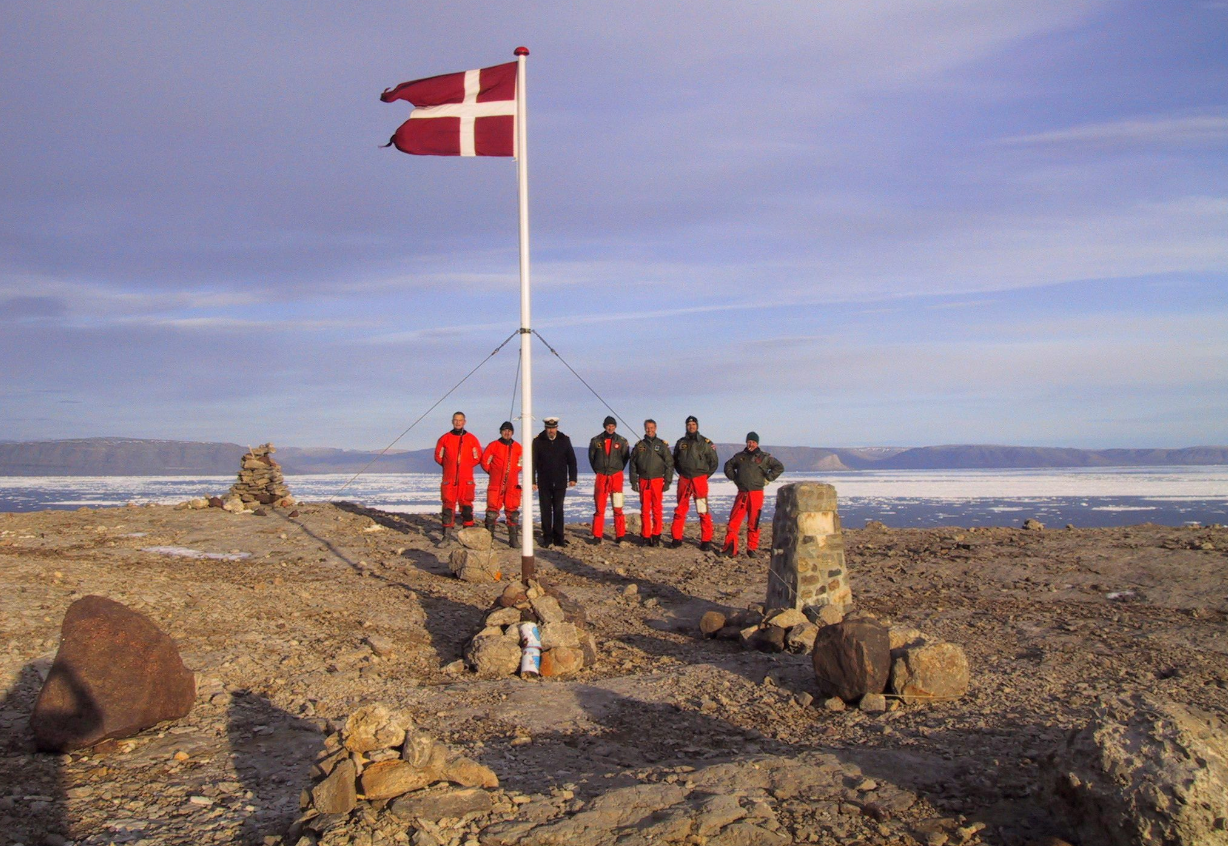 The crew of Danish warship Vedderen perform a flag raising ceremony on the uninhabitated Hans Island off northwestern Greenland, in this Aug. 13, 2002 file photo. Arctic experts from Canada and Denmark are proposing a novel solution to who controls an ice-bound speck of an island midway between the two countries.They say turn Hans Island into a condominium. (Polfoto, Vedderen/AP/The Canadian Press)