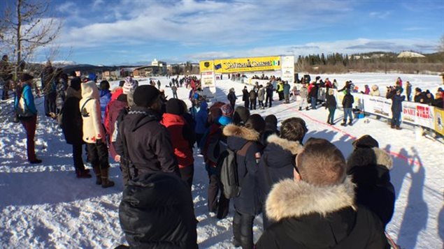 L'attente au soleil à la ligne d'arrivée du Yukon Quest. (Claudiane Samson/ICI Radio-Canada)
