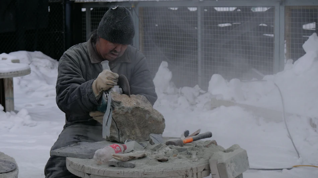 Originaire de la collectivité de Kinngait, sur l'île de Baffin, Mathewsie Kingwatsiak sculpte depuis l'âge de 16 ans. Photo : Radio-Canada / Matisse Harvey