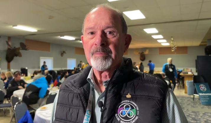 Image du président du comité international des Jeux d'hiver de l'Arctique (AWGIC), John Rodda., dans une salle.