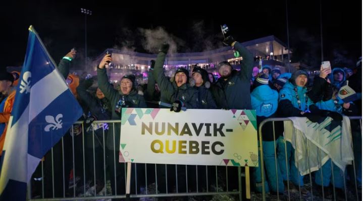 Rassemblement de gens derrière une affiche « Nunavik-Québec » ainsi qu'un drapeau du Québec