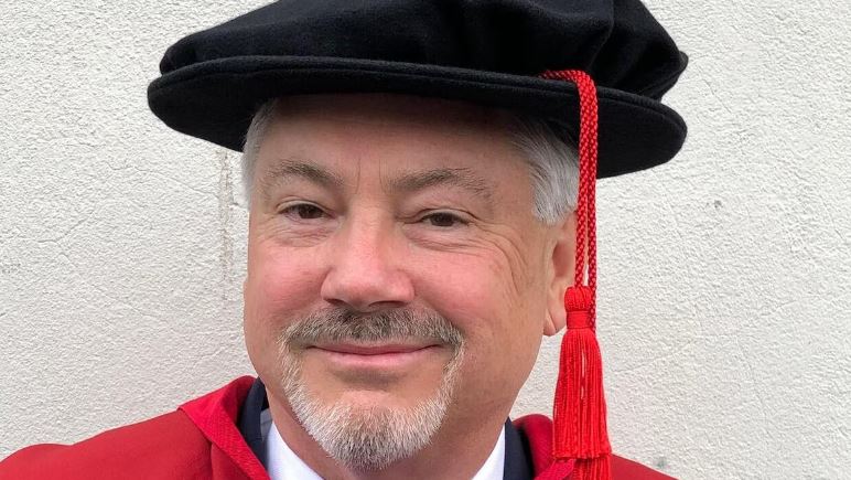 Brian Manarin, portant une robe d'avocat et un mortier.