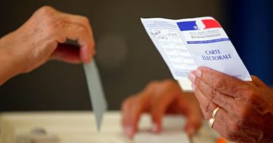 Une personne tient un bulletin de vote français.