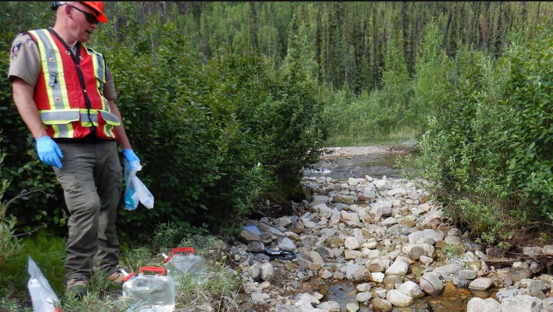 Un employé du gouvernement recueille des échantillons d'eau.