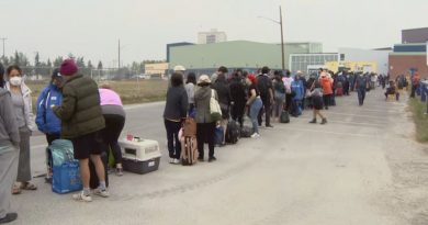 Des gens font la file devant un immeuble.