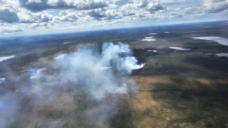 Vue aérienne d'un feu qui brûle dans un terrain vaste.