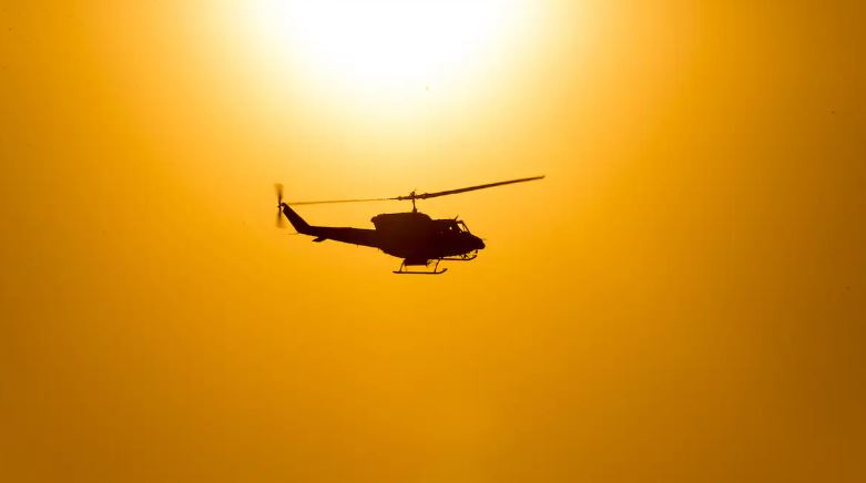 Image d'un hélicoptère entouré d'un ciel jaune.