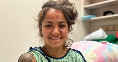 Une femme ayant des éraflures au visage sourit à la caméra.