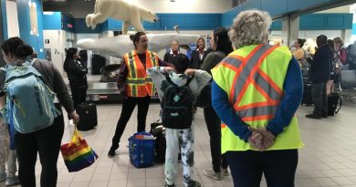 La mairesse Rebecca Alty parle à des gens dans un aéroport.