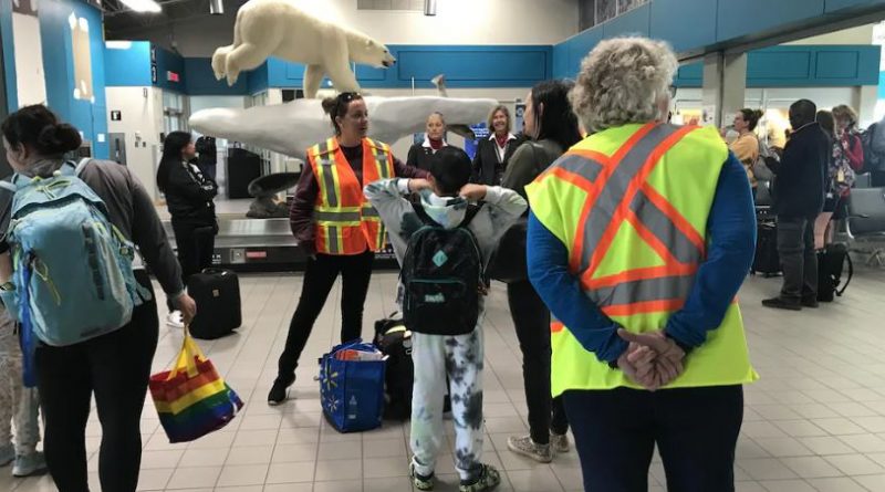 La mairesse Rebecca Alty parle à des gens dans un aéroport.