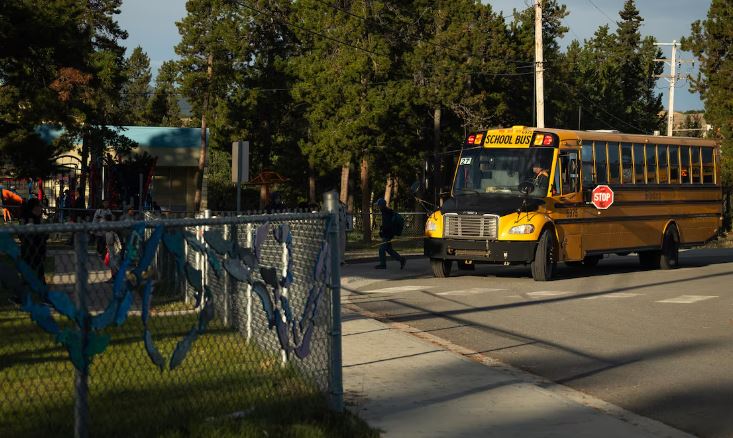 Un autobus dépose des enfants à l'école