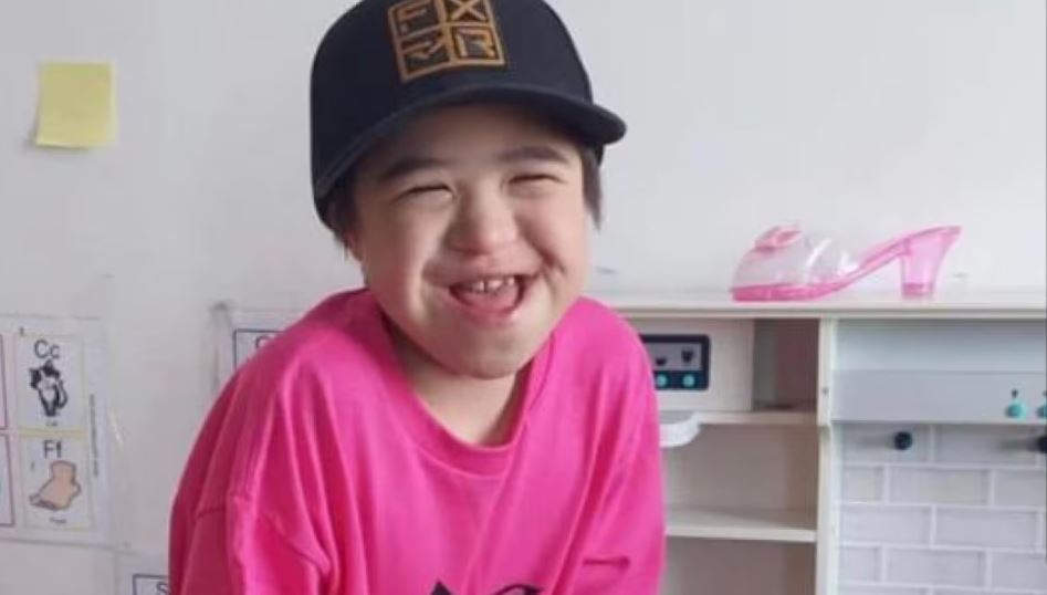 Un enfant sourit à la caméra.