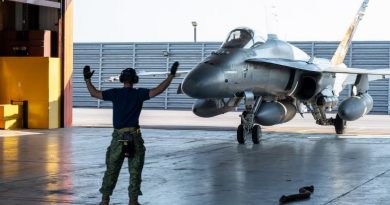 Un homme guide un avion dans un hangard