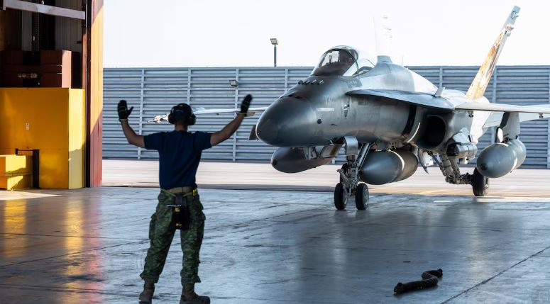 Un homme guide un avion dans un hangard