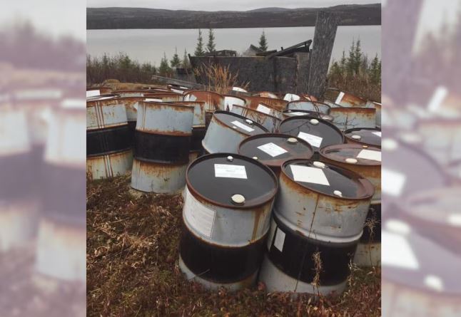 Des barils de diesel abandonnés près d'un lac.