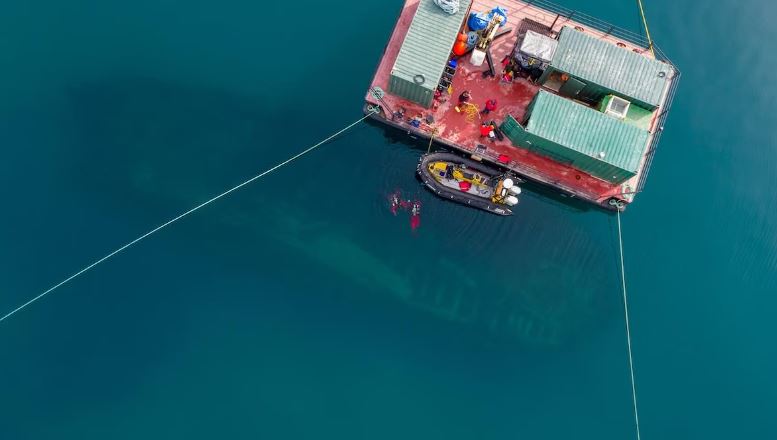Une barge dans l'Arctique, vue depuis le ciel. En profondeur, la forme de l'Erebus apparaît.