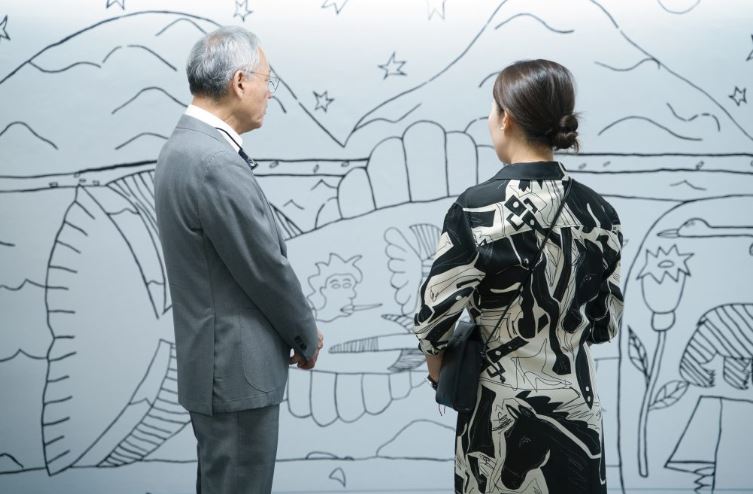 Deux personnes observent une oeuvre d'art.