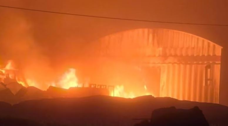Un bâtiment en flammes dans la nuit.