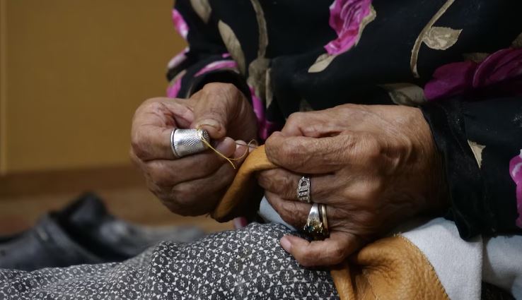 Les mains de Annie Atighioyak en train de coudre de la peau tannée à Cambridge Bay.