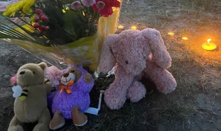 Oursons en peluche et fleurs déposés au sol, à Wetaskiwin, en Alberta.