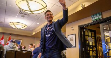Le chef du Parti conservateur, Pierre Poilievre, lève la main vers le ciel en souriant, dans une salle de conférence, à l'hôtel Frobisher Inn d'Iqaluit, le 9 septembre 2024.