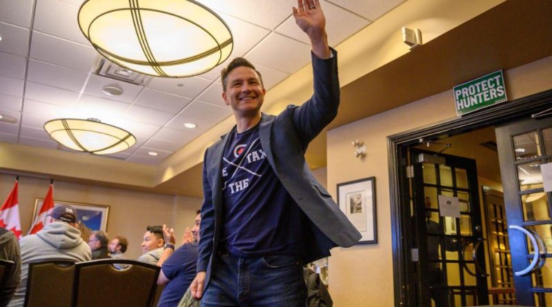 Le chef du Parti conservateur, Pierre Poilievre, lève la main vers le ciel en souriant, dans une salle de conférence, à l'hôtel Frobisher Inn d'Iqaluit, le 9 septembre 2024.