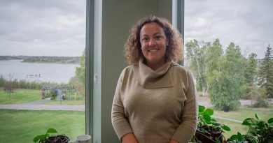 Un femme regarde la caméra en souriant