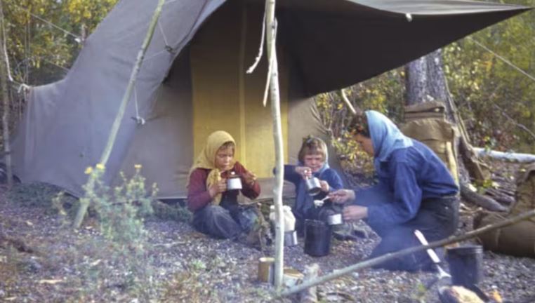 Ruth Albee et ses enfants, Jo Evelyn et Billy, au Yukon en 1940, en train de manger sous une tente.
