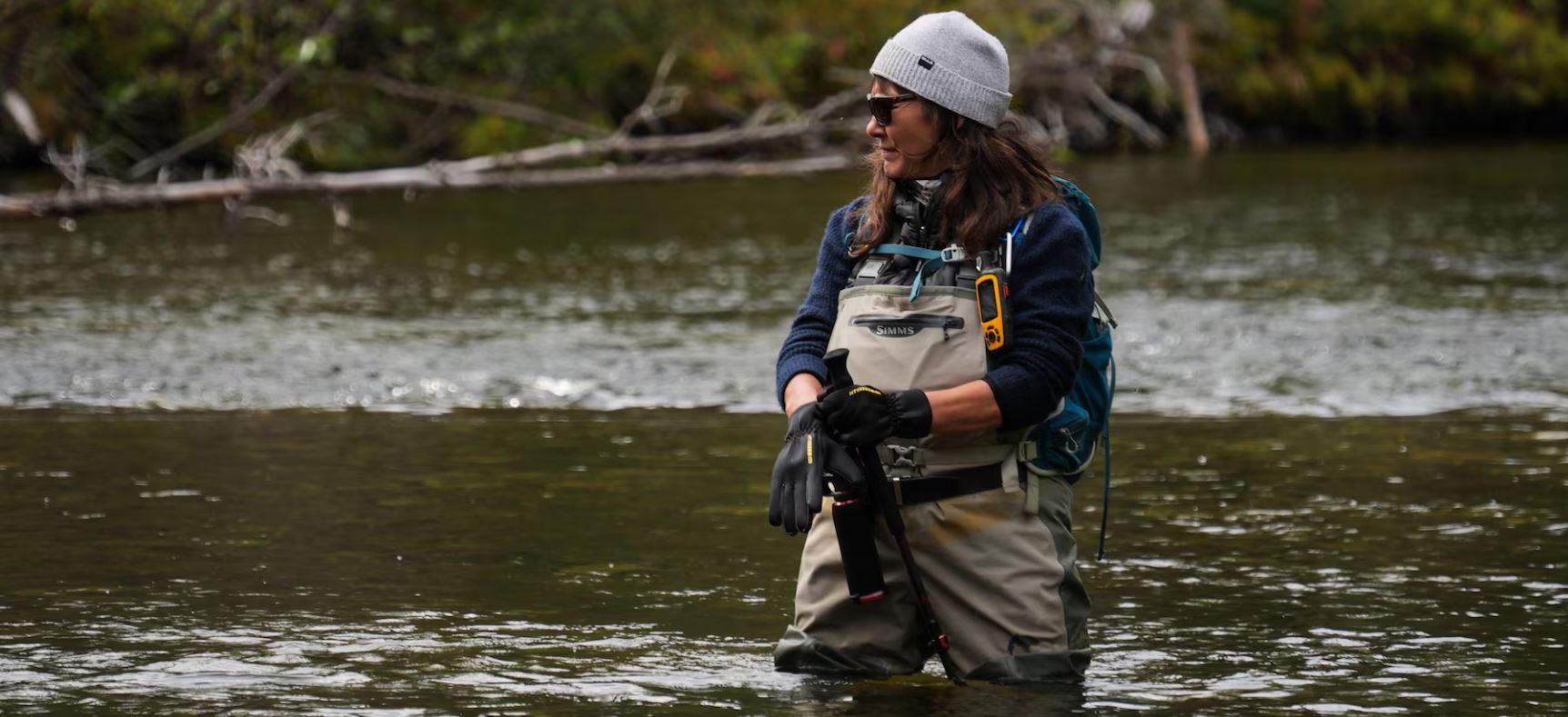 Brandy Mayes enfile des gants, debout dans l'eau jusqu'aux cuisses.