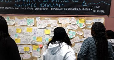 Des personnes regardent un tableau.