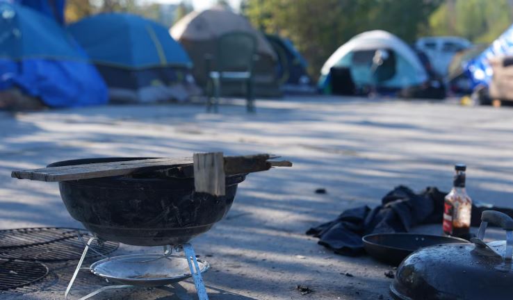 Barbecue sur un terrain de stationnement, avec des tentes au loin, le 6 septembre 2024, à Yellowknife,