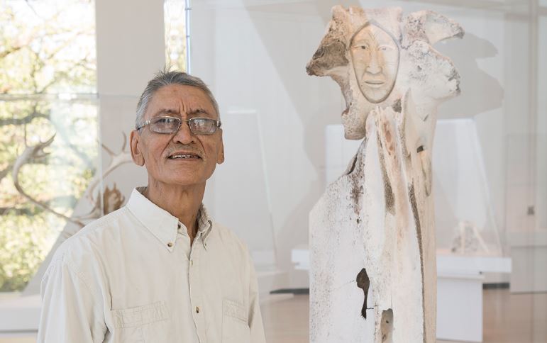 L'artiste Manasie Akpaliapik regarde la caméra en souriant.