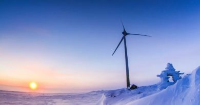 Une éolienne sur un sol enneigé.