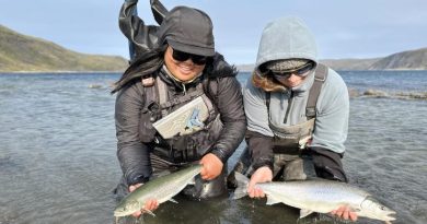 Deux pêcheuses tiennent des ombles de l'Arctique.