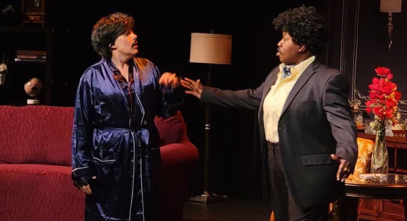 Deux personnes sur scène lors d'une pièce de théâtre, en costume.