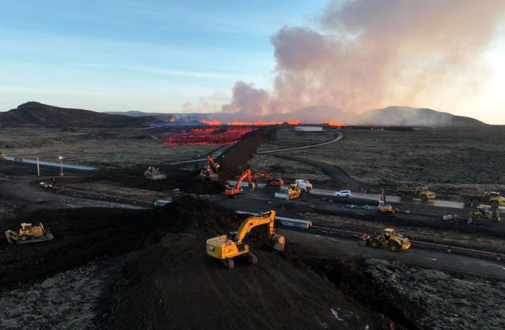 Des grues tentent d'empêcher la lave de détruire tout le territoire.